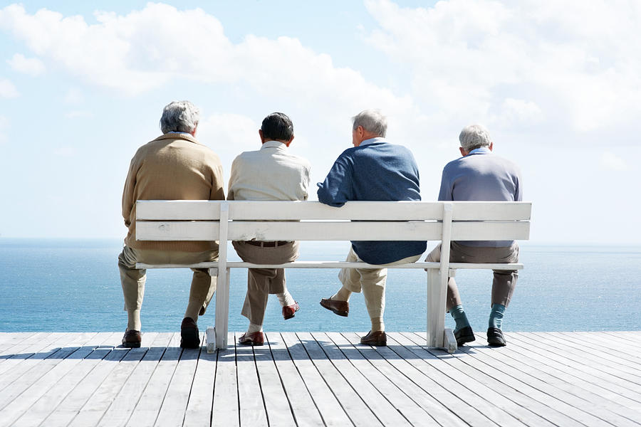 Group of old male friends sitting together on bench Photograph by Jacob Wackerhausen