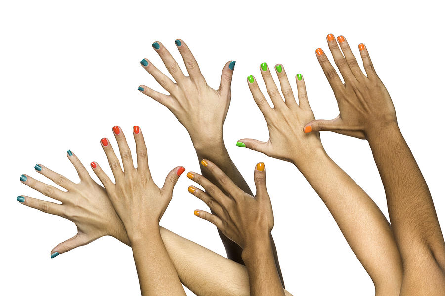 Group of raised multiethnics female hands with colored manicure Photograph by Apomares