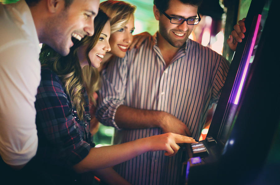 Group of young adults having fun in casino. Photograph by Gilaxia
