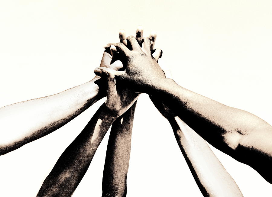 Group of young peoples hands clasped together (toned B&W) Photograph by Robert Daly