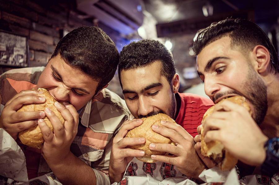 Guys eating burgers Photograph by Jasmin Merdan
