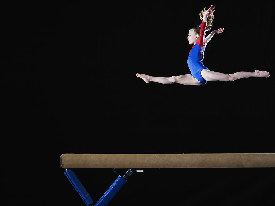 Gymnast (9-10) leaping on balance beam Photograph by Thomas Barwick