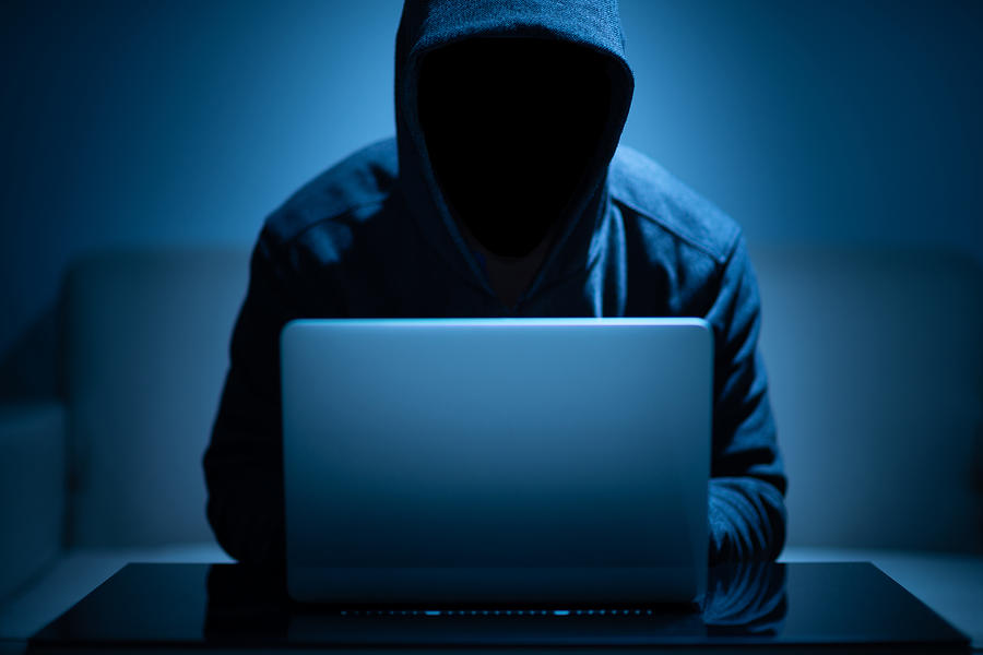 Hacker dark face using laptop Photograph by Spyarm