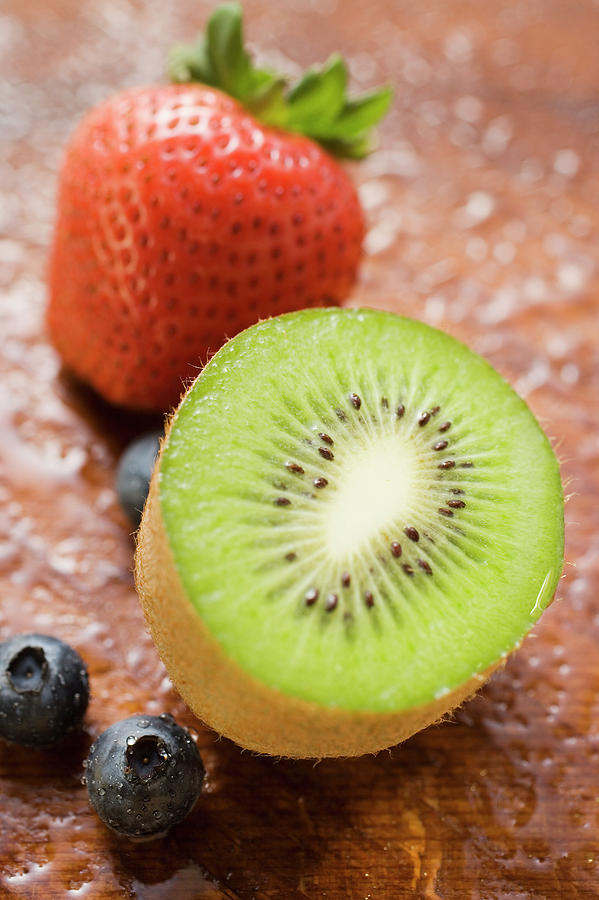 Still Life Photograph - Half A Kiwi Fruit, Blueberries And Strawberry by Foodcollection