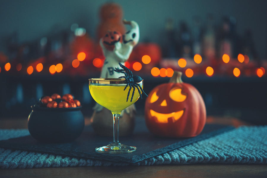 Halloween time. Vibrant colored drinks with cauldron of candy Photograph by CatLane