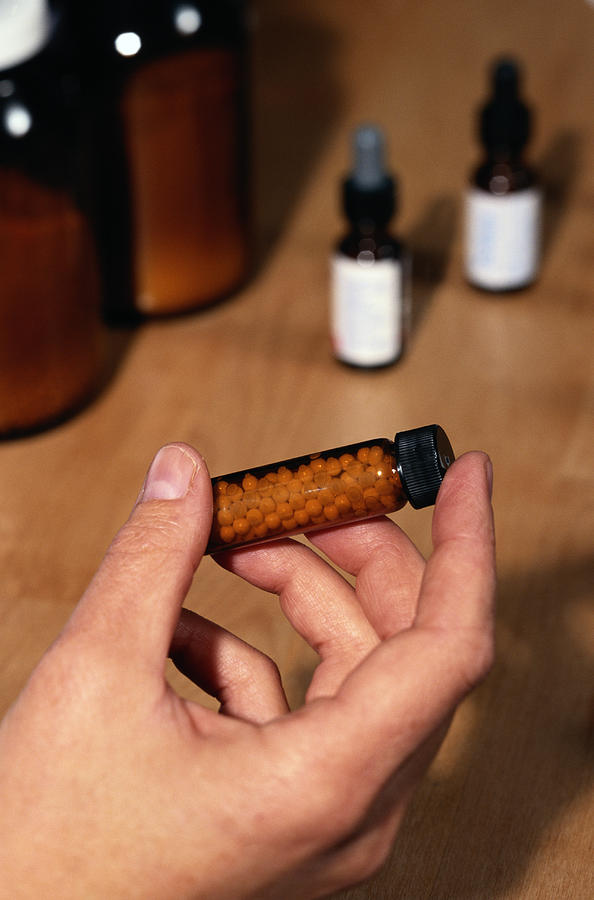 Hand Holding a Bottle of Homeopathic Medicine Photograph by Keith Brofsky