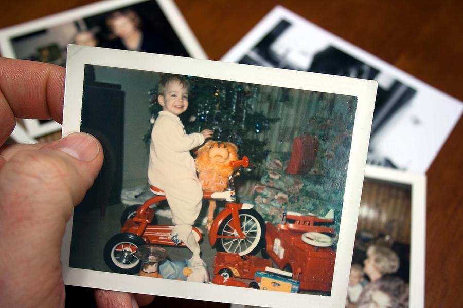 Hand holds Vintage photograph of boy on tricycle at christmas Photograph by Catscandotcom