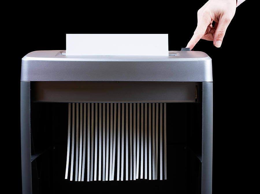 Hand operating paper shredder  Photograph by Hup