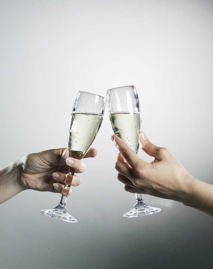 Hands holding and toasting champagne flutes Photograph by Robert Daly