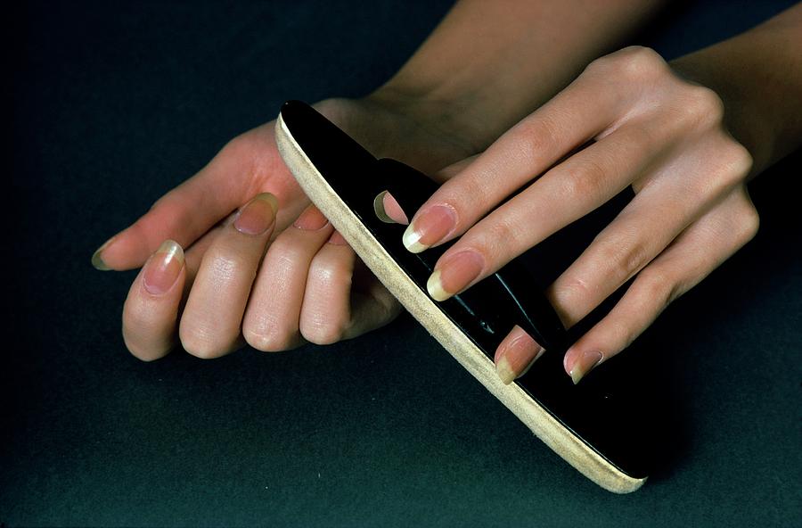 Hands Of A Model Using A Nail Buffer Photograph by William Connors