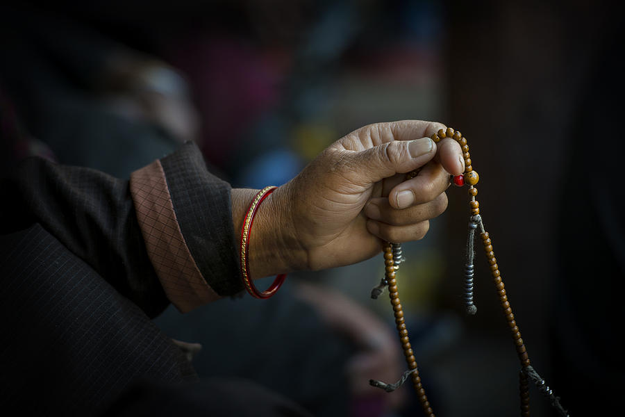 Hands of a Tibetan Buddhist with his prayer beads Photograph by Guenterguni