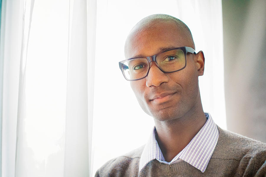 Handsome mature black male bald intellectual portrait by window Photograph by NicolasMcComber