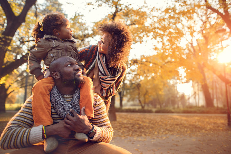 Happy African American family enjoying in nature during autumn. Photograph by Skynesher