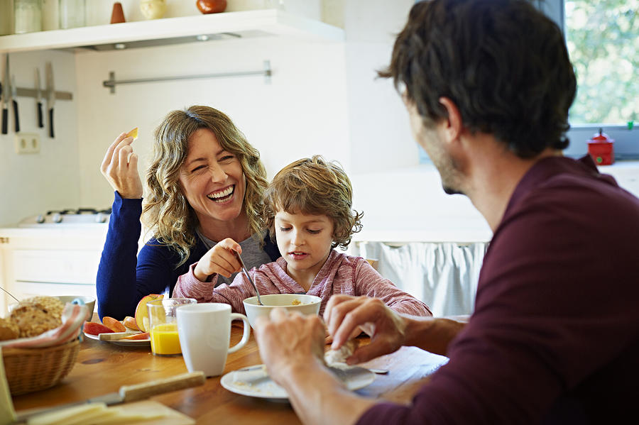 Happy family enjoying breakfast at table Photograph by Morsa Images