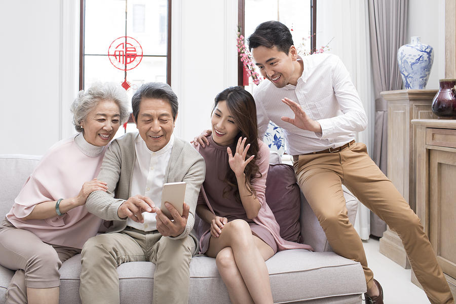 Happy Family Having Video Chat On Smart Phone During Chinese New Year By Lane Oatey Blue Jean Images