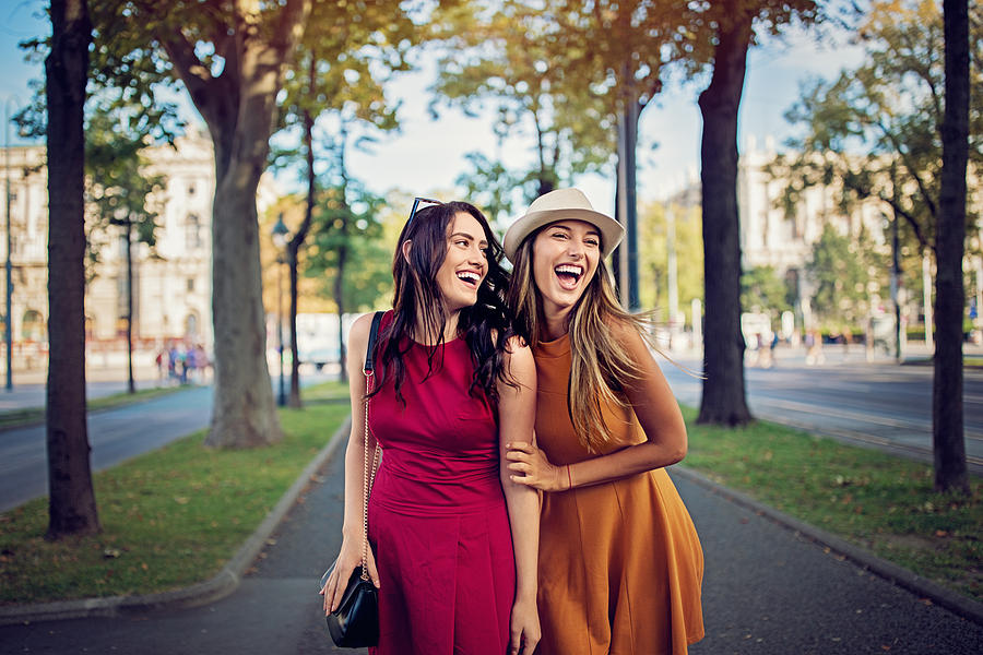 Happy girlfriends are walking and hugging in the city and make fun together Photograph by Praetorianphoto