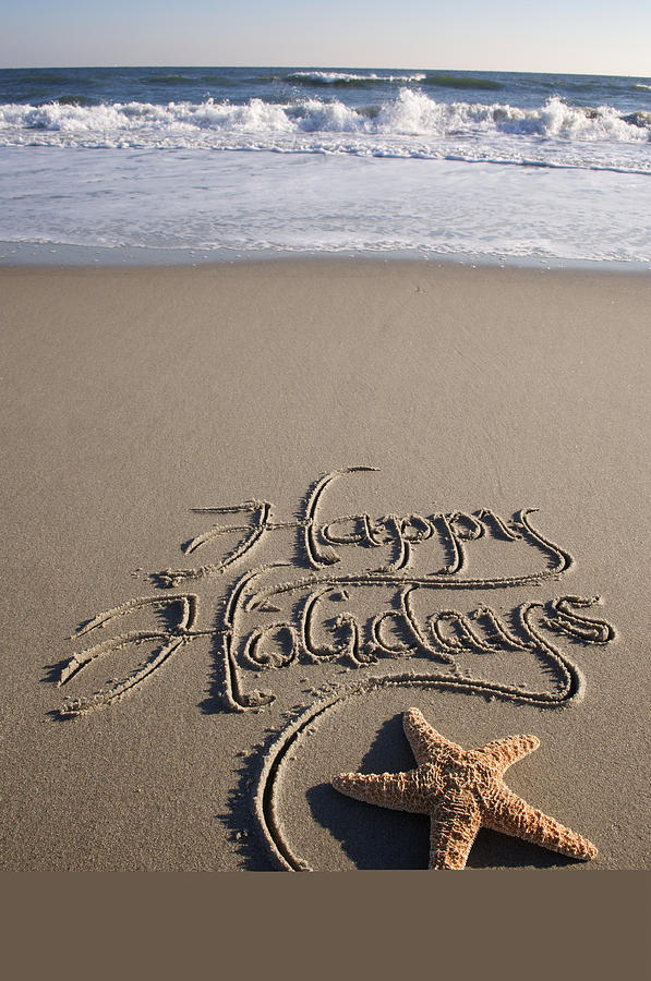 Happy Holidays Message Handwritten on Beach with Crashing Waves Photograph by PeskyMonkey