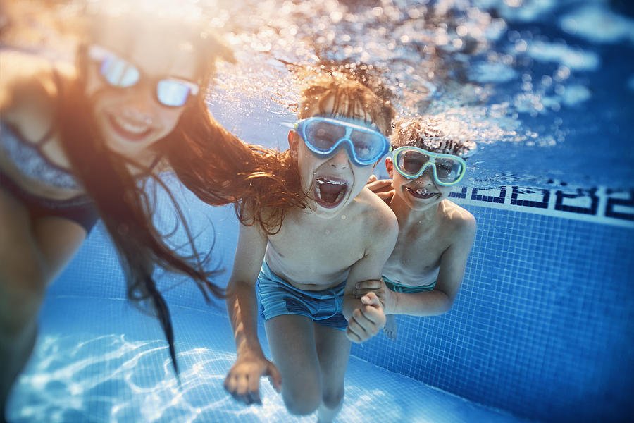 Happy kids playing underwater Photograph by Imgorthand