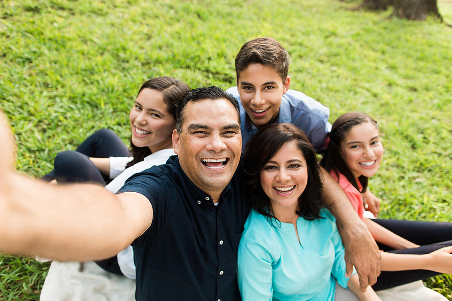 Happy latin familly taking a selfie outdoors Photograph by Aldo Murillo