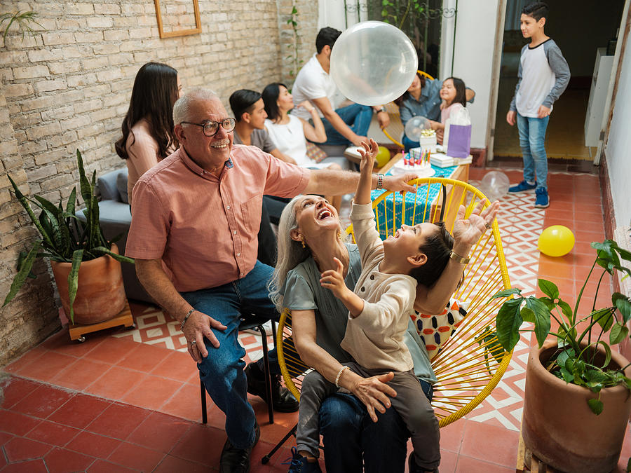 Happy mexican grandparents and grandson playing with balloon Photograph by Aldomurillo