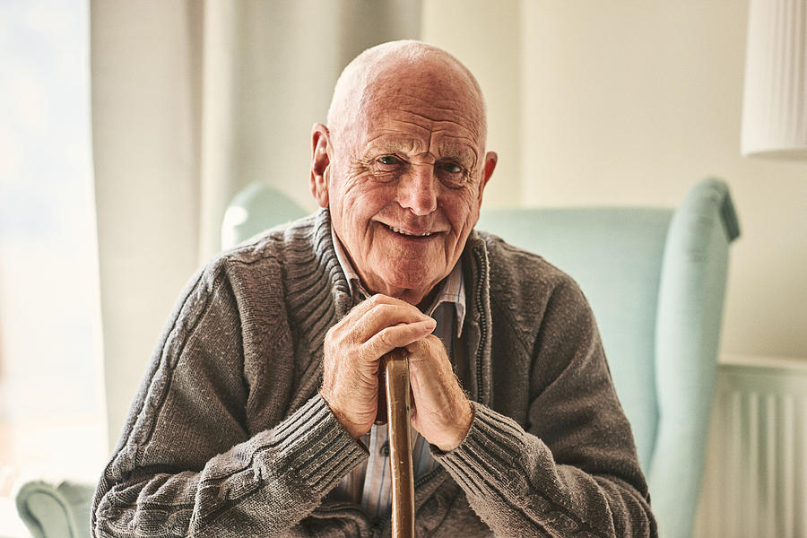 Happy senior man sitting at home Photograph by Dean Mitchell