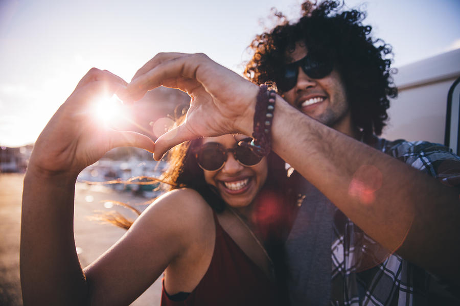 Happy young hipster couple making heart shape with hands Photograph by Wundervisuals
