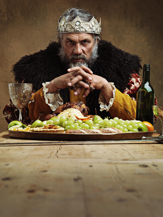 He feasts while the serfs starve Photograph by Yuri_Arcurs