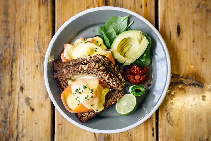 Healthy breakfast with rye bread, salmon, poached egg, avocado and lime Photograph by Alexander Spatari