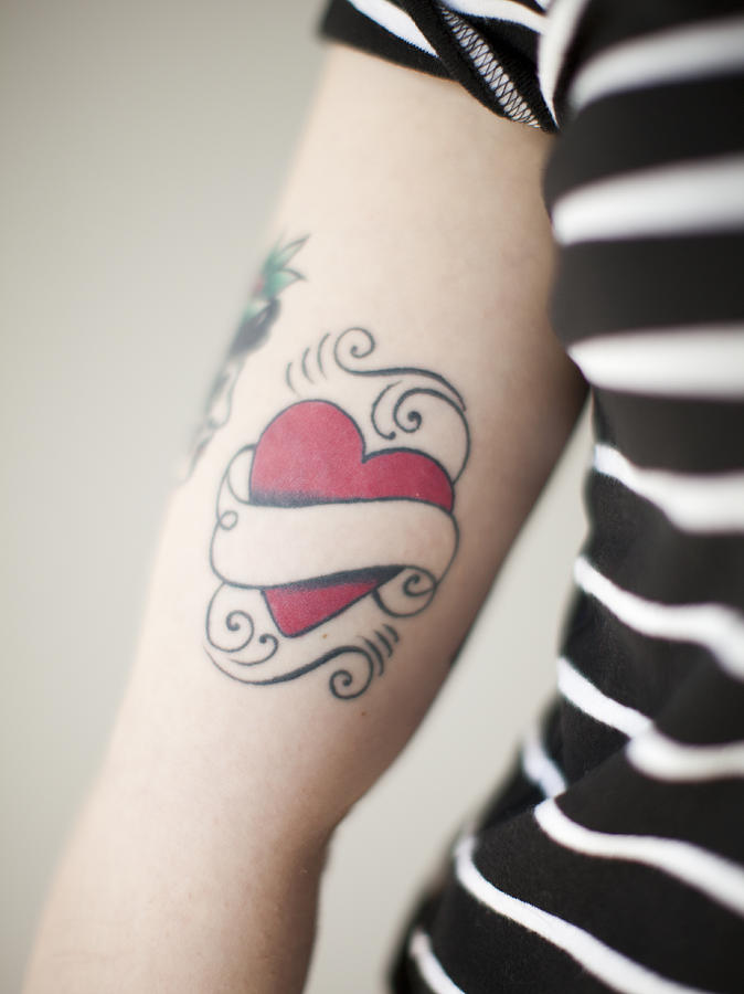 Heart shaped tattoo on womans arm Photograph by Tetra Images - Jessica Peterson