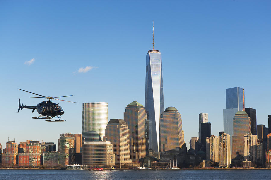 Helicopter flying over river, New York, USA Photograph by Ditto