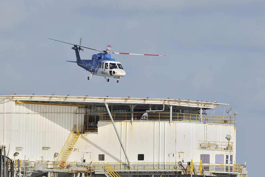 Helicopter landing on oil rig Photograph by Bradford Martin
