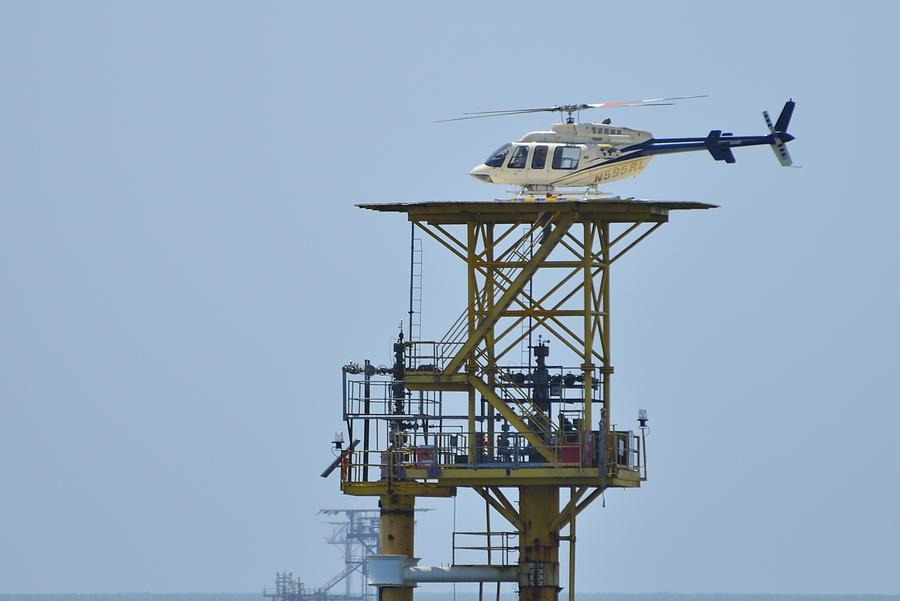 Helicopter on oil rig Photograph by Bradford Martin