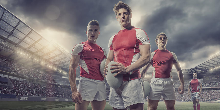 Heroic Rugby Players Standing With Ball On Pitch In Stadium Photograph by Peepo