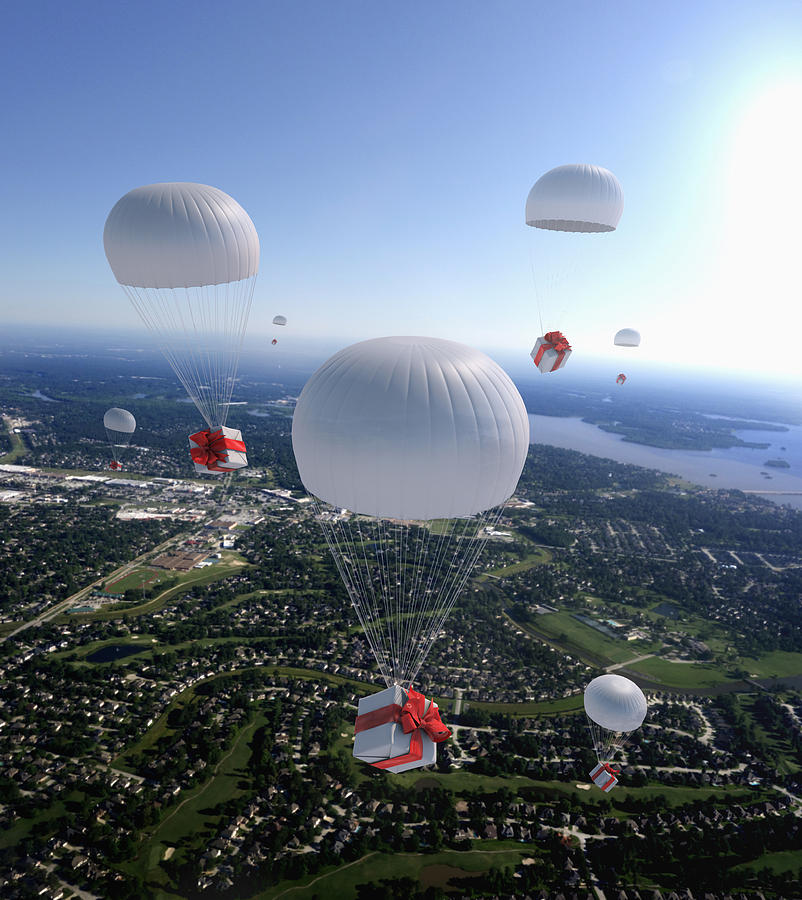 High angle view of gifts parachuting over suburban cityscape Photograph by Colin Anderson Productions pty ltd