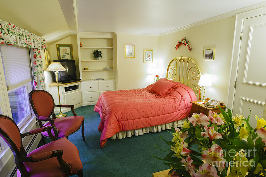 High end hotel bedroom with flowers. Photograph by Don Landwehrle