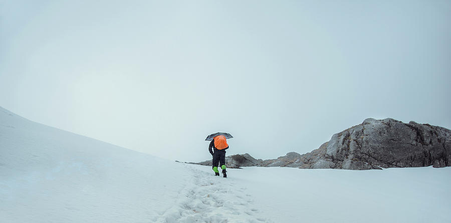 Winter Photograph - Hiker With Umbrella Walking Over Snowy by Marko Radovanovic