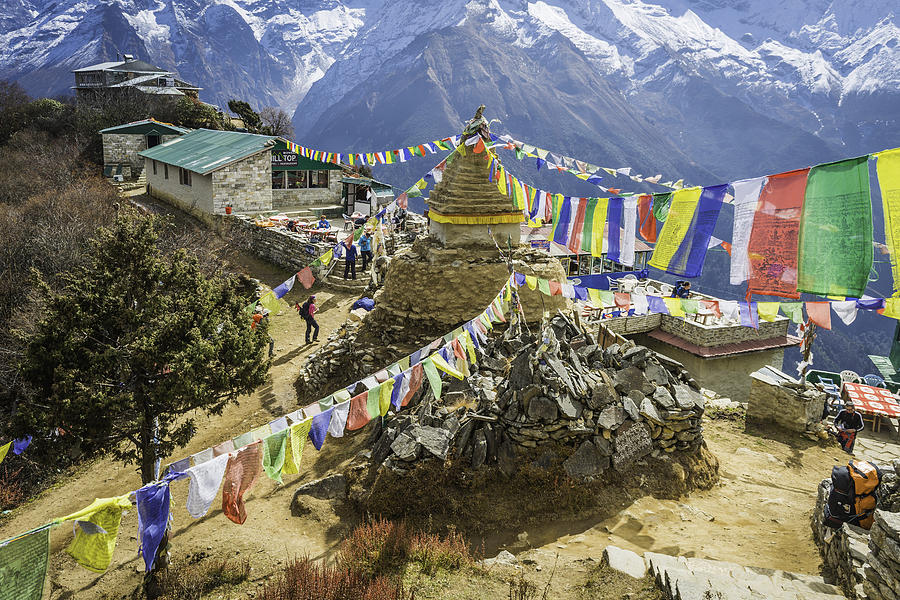 Hikers trekking colourful Buddhist prayer flags Everest trail Himalayas Nepal Photograph by fotoVoyager