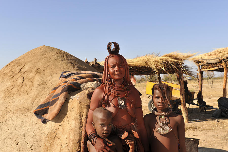Himba woman with children standing near hut , Opuwo,Namibia Photograph by Brytta