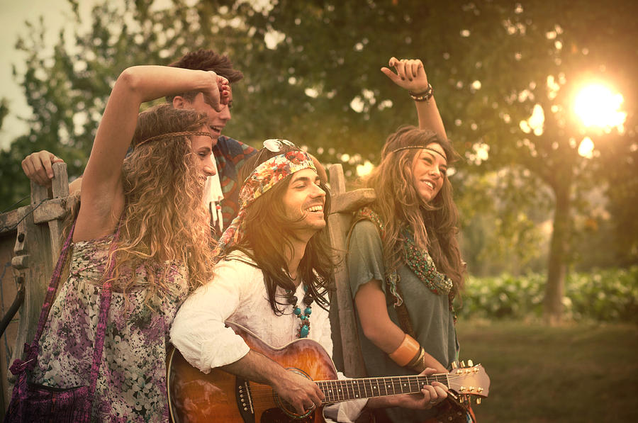 Hippies Dancing and Playing Guitar . 1970s style. Photograph by SeanShot