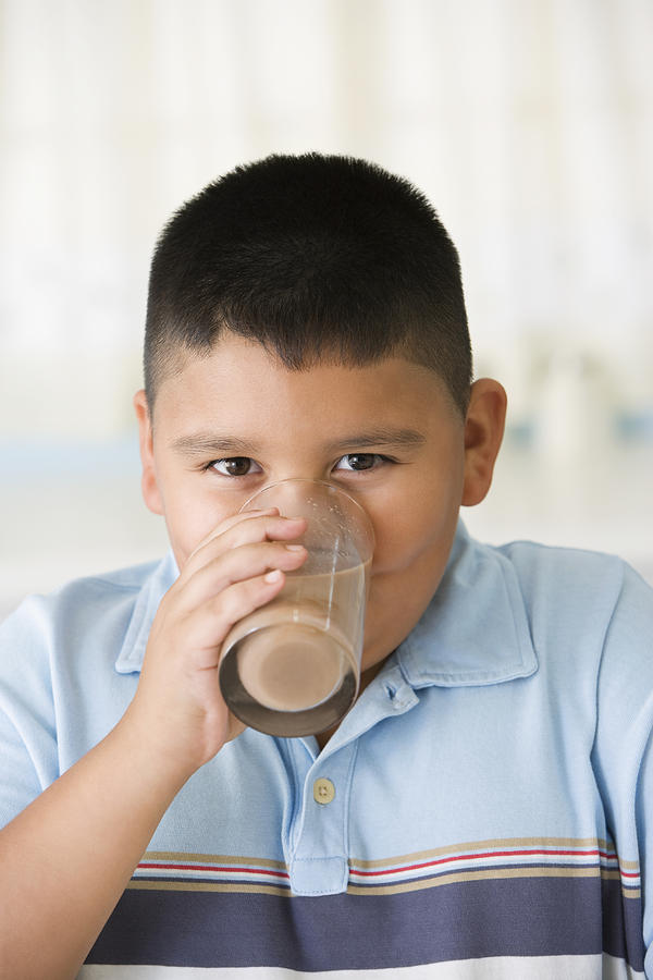 Hispanic boy drinking chocolate milk Photograph by Jose Luis Pelaez Inc