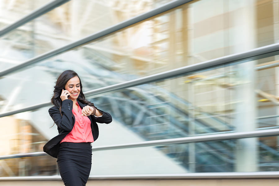 Hispanic Business Women On Phone Walking In A Rush Photograph by MichaelSvoboda