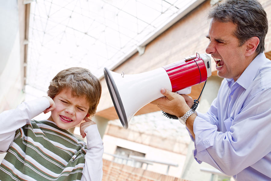 Hispanic father shouting at son through bullhorn Photograph by Andres Rodriguez