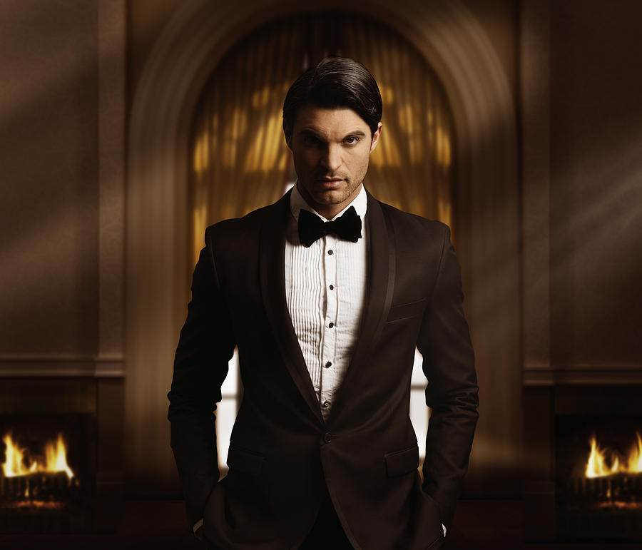 Hispanic man in tuxedo standing in living room Photograph by Colin Anderson Productions pty ltd