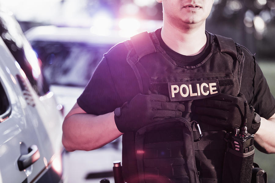 Hispanic police officer wearing bulletproof vest Photograph by Kali9