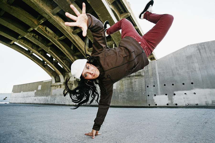 Hispanic woman break dancing under overpass Photograph by Peathegee Inc