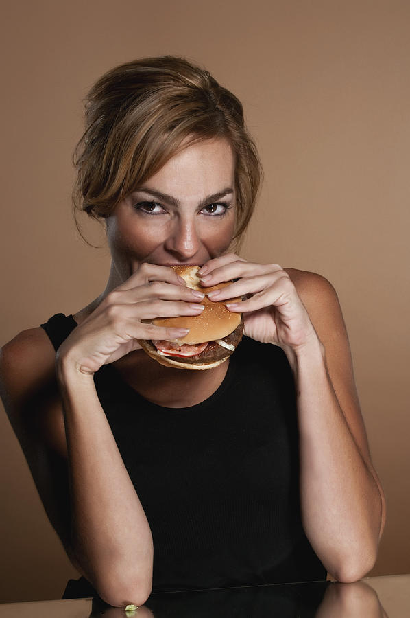 Hispanic Woman Having a Hamburger Photograph by Juanmonino
