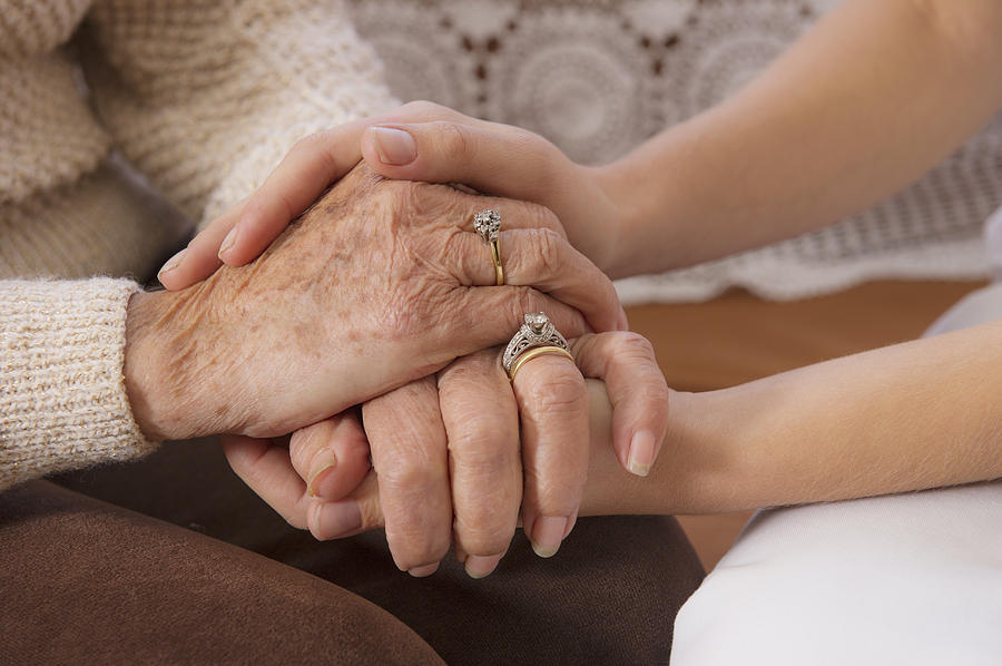 Hispanic woman holding hands with senior woman Photograph by Jacobs Stock Photography Ltd