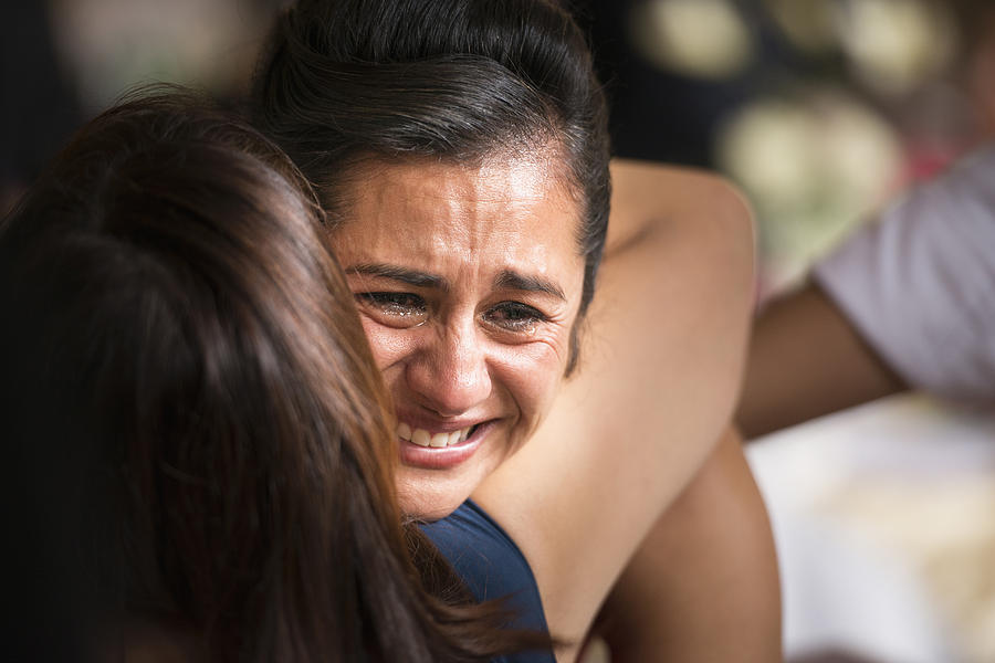 Hispanic women hugging and crying Photograph by Steve Peixotto Photography