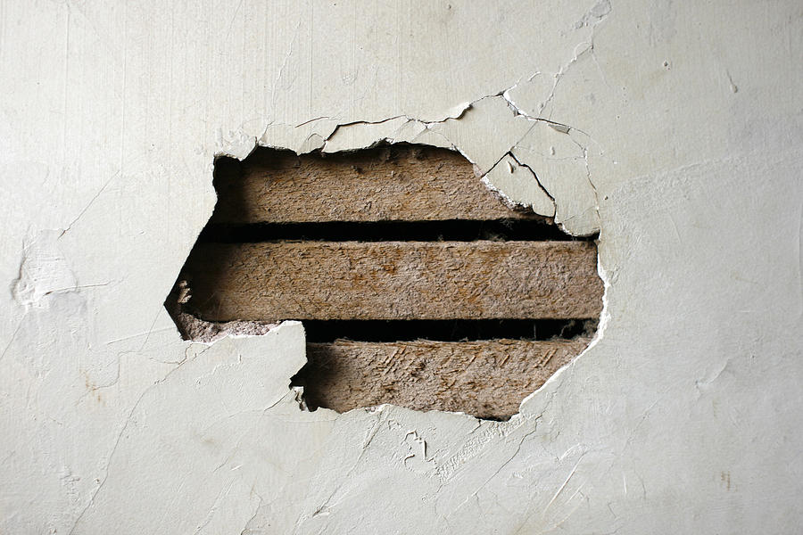 Hole in Plaster Wall - Exposed Wood Paneling Photograph by Jitalia17