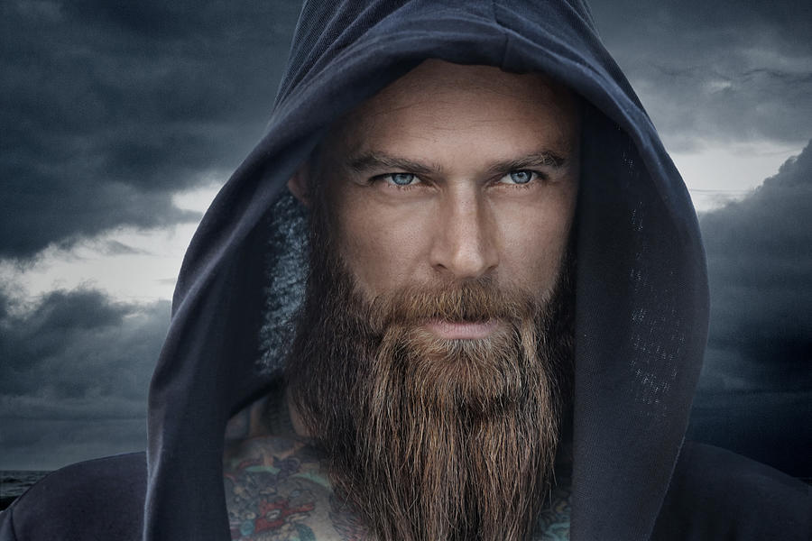 Hooded bearded tattooed male in fantasy cloudy seascape setting Photograph by Lorado